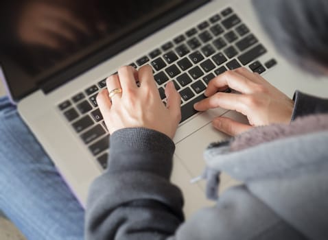 Woman sitting on the floor using laptop, stock photo