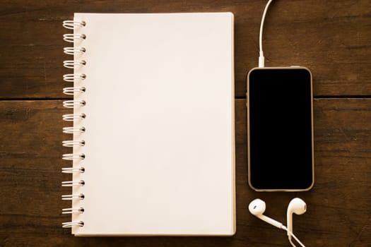 Notepaper and smart phone on wooden table, stock photo