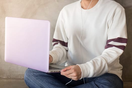Woman sitting on the floor using laptop, stock photo
