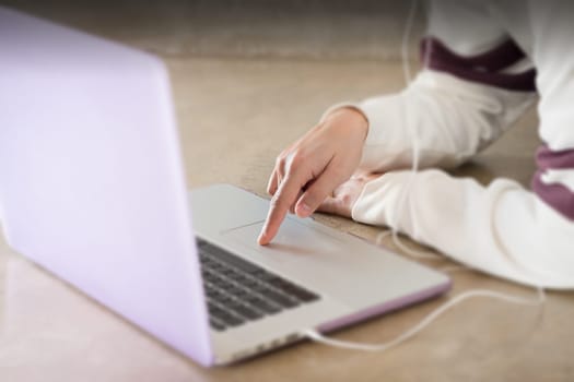 Woman sitting on the floor using laptop, stock photo