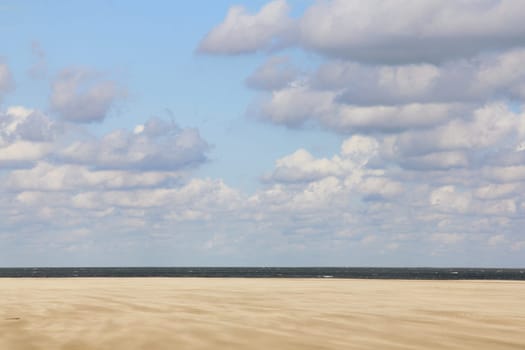 Lonely sandy beach,with blue sky and few clouds.