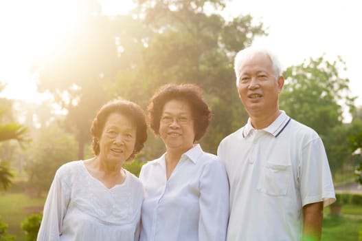 Group of healthy Asian seniors having good time at outdoor nature park, in morning beautiful sunlight at background.