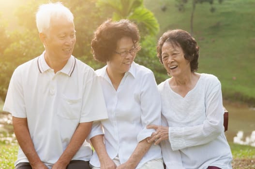 Portrait of healthy Asian seniors group having fun at outdoor nature park, in morning beautiful sunlight at background.