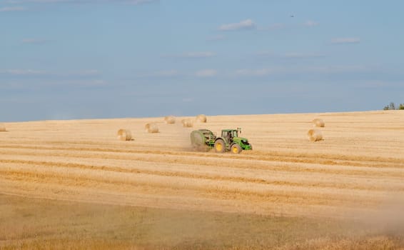Tractor collecting straw can be used as background