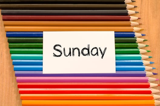 Blank white paper and colored pencils on wooden background