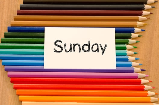 Blank white paper and colored pencils on wooden background