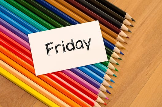 Blank white paper and colored pencils on wooden background