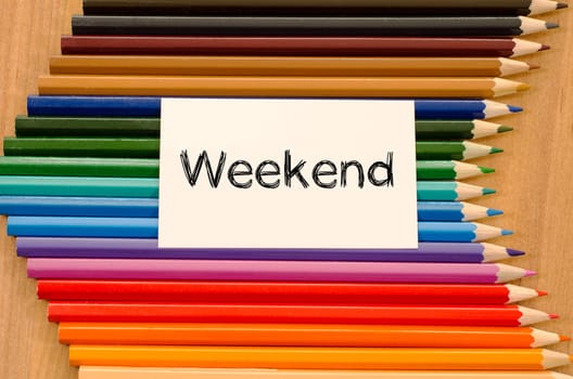 Blank white paper and colored pencils on wooden background