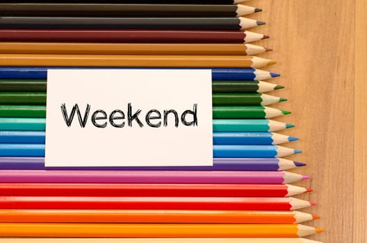 Blank white paper and colored pencils on wooden background