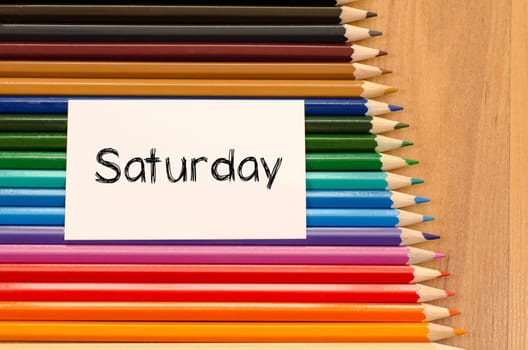 Blank white paper and colored pencils on wooden background