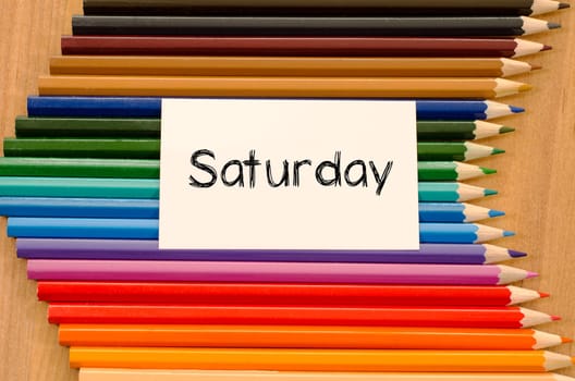 Blank white paper and colored pencils on wooden background