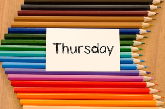 Blank white paper and colored pencils on wooden background
