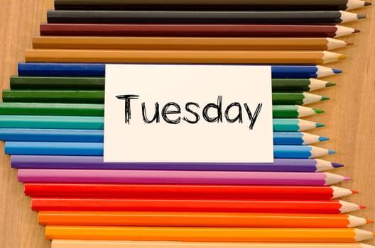 Blank white paper and colored pencils on wooden background