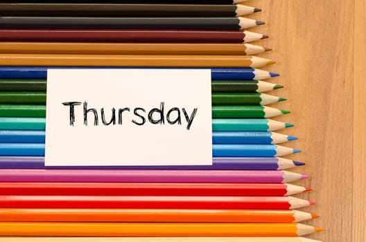 Blank white paper and colored pencils on wooden background