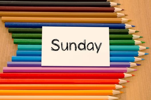 Blank white paper and colored pencils on wooden background