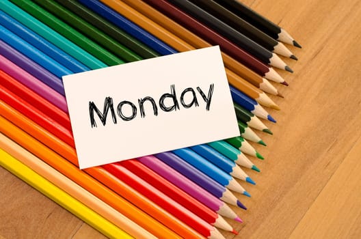 Blank white paper and colored pencils on wooden background