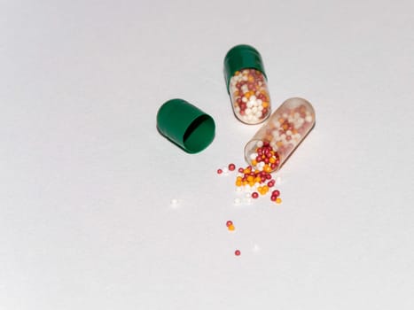 Tabs Vitamins, omega 3, Medications tablets and capsules in a beaker. Medications tablets, suppository bottles, capsules and thermometer on wooden table