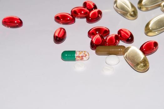 Tabs Vitamins, omega 3, Medications tablets and capsules in a beaker. Medications tablets, suppository bottles, capsules and thermometer on wooden table