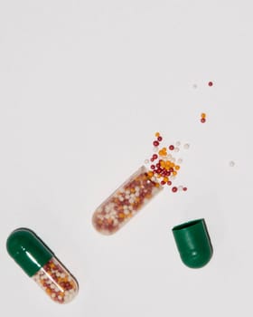 Tabs Vitamins, omega 3, Medications tablets and capsules in a beaker. Medications tablets, suppository bottles, capsules and thermometer on wooden table
