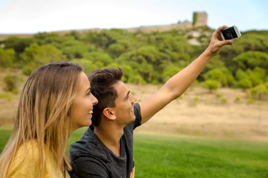 Portrait of a young beautiful couple lying on the grass