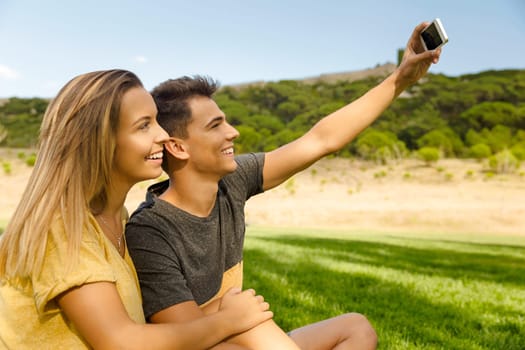 Portrait of a young beautiful couple lying on the grass