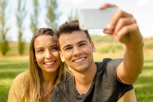 Portrait of a young beautiful couple lying on the grass