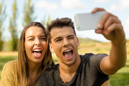 Portrait of a young beautiful couple lying on the grass