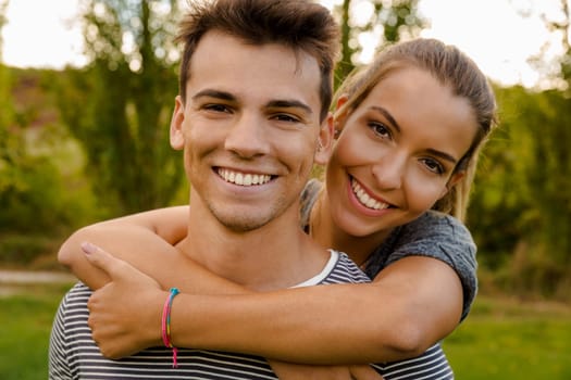 Portrait of a happy young couple embraced together