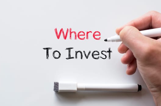 Human hand writing where to invest on whiteboard