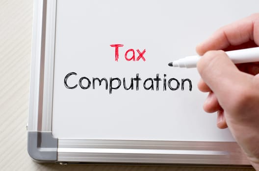 Human hand writing tax computation on whiteboard