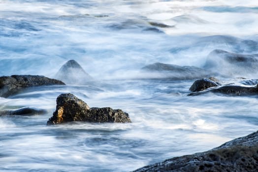 Surf of the Atlantic Ocean with rocks in long exposure