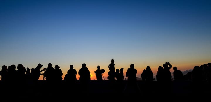Silhouette tourists and photographers with beautiful sunrise on Inthanon mountain in Chiang Mai, Thailand