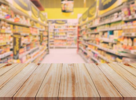 Empty wooden table with blurred supermarket background. For product display business concept.