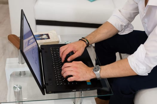 Laptop with hands on table.