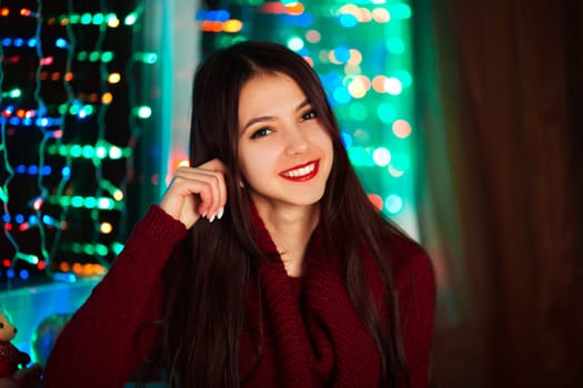 Smiling happy girl in red sweater in studio