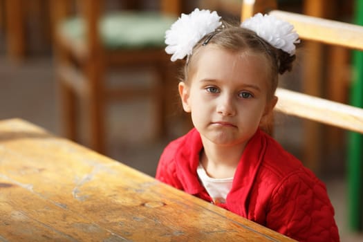 Little girl in a red jacket. Shallow depth of field. Selective focus.