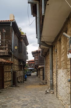 Nesebar, Bulgaria - September 08, 2014: Narrow street with old houses in the seaside resort and ancient old town Nessebar in Bulgaria. UNESCO world heritage site. Vertical shot.