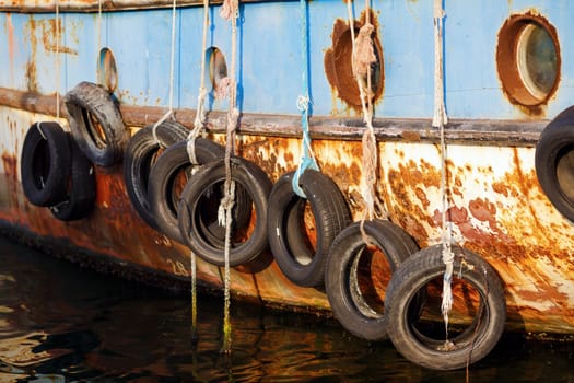 Nesebar, Bulgaria - September 10, 2014: Old ship Nymph in the port of the old town of Nessebar, Bulgaria. Old tires on ship. used for impact protection of a ship. Selective focus.