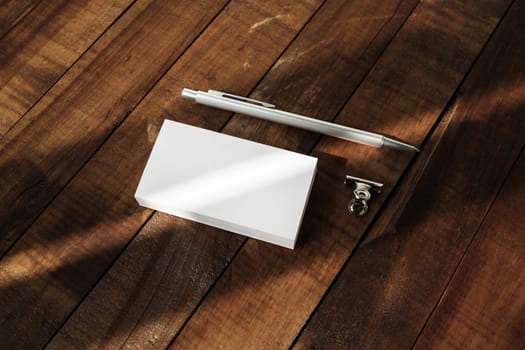 Photo of blank business cards and pen on vintage wooden table background. Blank template for placing your design. Mockup for branding identity.