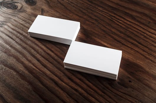 Photo of blank business cards on a wooden background. Template for ID.