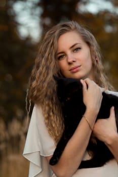 Attractive beautiful pretty lovely stunning snorting nice adorable girl with black cat.Very beautiful girl hold cute cat,black cat.Attractive woman,model,blonde girl with long hair and lovely cat,cat.Cheerful,happy and smiling girl with perfect smile