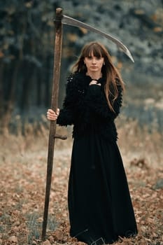 Closeup picture of pretty serious beautiful girl with long hair in black clothes with braid on dark forest background. Serious mystical girl with serious face and braid on Halloween party.