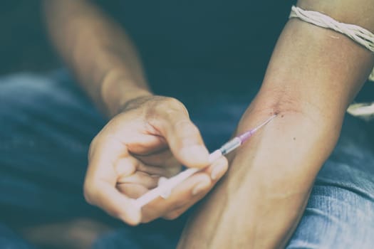 drug addict man with syringe in action
