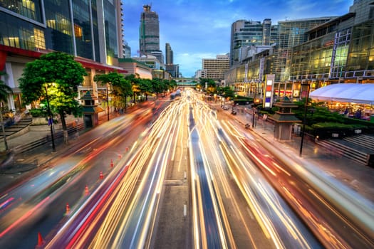Busy street in the city at dusk,full of car light streaks dynamic blue hour shot with long exposure motion blur effect