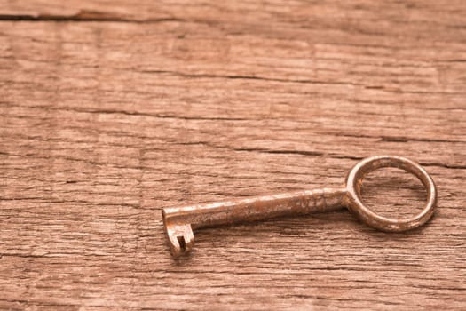 Old key with rust on wooden board