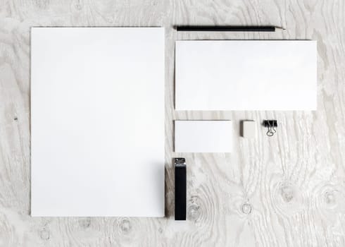 Photo of blank stationery set. Corporate identity template on light wooden background. Mock up for placing your design. Responsive design mockup. Top view.