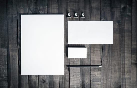 Photo of blank stationery set on wood background. Blank stationery and corporate identity template. Blank letterhead, business cards, envelope and pencil. Responsive design mockup. Top view.