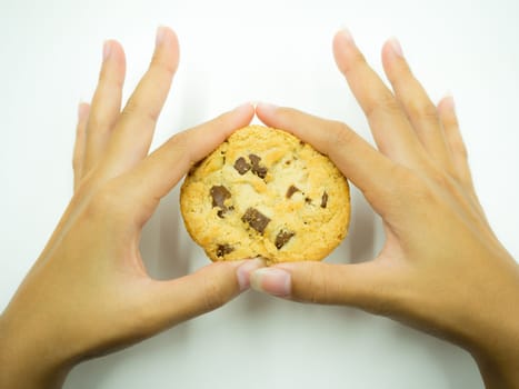 Woman's hand holding stack of chocolate chip cookies