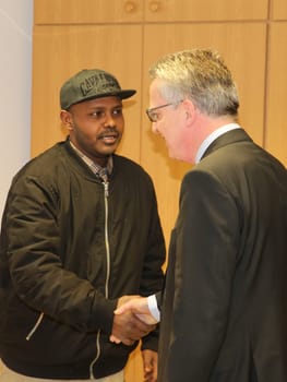 Federal Interior Minister Thomas de Maizière (CDU) welcomes refugee Hashem Gassin from Sudan to the Magdeburg City Mission on 21.02.2017