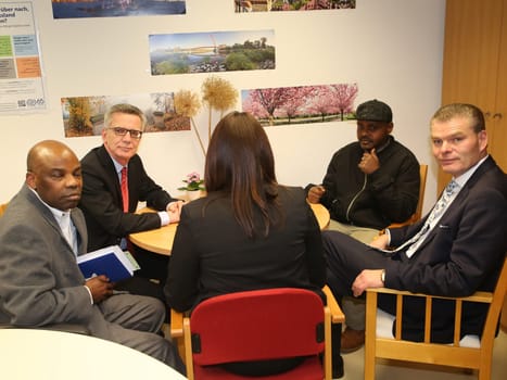 Federal Interior Minister Thomas de Maizière (CDU) (2nd from left) with refugee Hashem Gassin (2nd right) from Sudan in Magdeburg city mission on 21.2.17